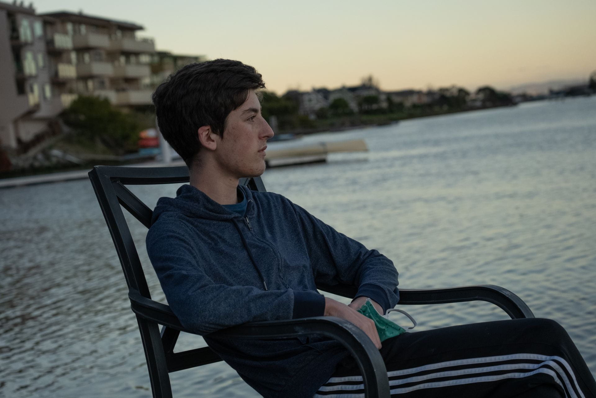 Jordan sits on the dock of the California creek he lives on, looking out over the water contemplatively.